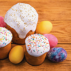 Easter cakes and Easter colored eggs on a wooden background.