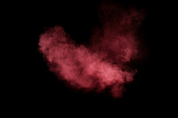 Fototapeta na wymiar Red and pink powder explosion on black background. Colored powder cloud. Colorful dust explode. Paint Holi.