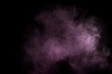 Purple powder explosion on black background. Colored powder cloud. Colorful dust explode. Paint Holi.