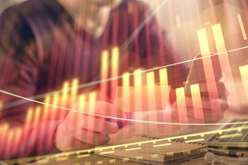 Obraz premium Double exposure of man's hands holding and using a phone and financial graph drawing. Analysis concept.