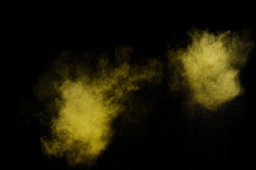 Yellow powder explosion on black background. Colored powder cloud. Colorful dust explode. Paint  Holi.