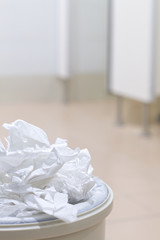 White used paper tissue in overcrowded bin