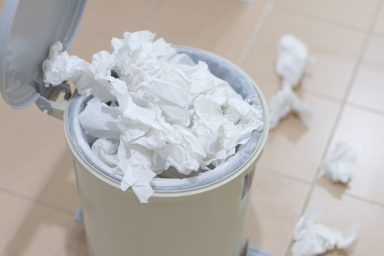 White used paper tissue in overcrowded bin