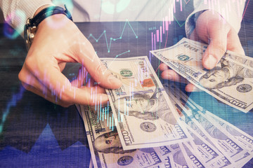 Multi exposure of financial graph drawing hologram and USA dollars bills and man hands. Analysis concept.