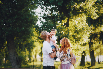 Fototapeta premium Beautiful red-haired woman with her husband and a wonderful son on a summer park
