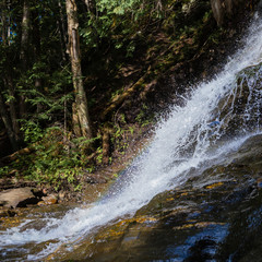 A rainbow appears from the side view of the bottom of Beaver Brook Falls