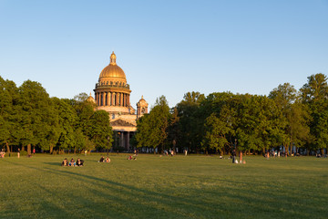  Lawn on Senate Square with people resting in front of St. Isaac's Cathedral. Saint Petersburg,...