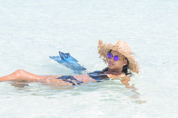 Hispanic woman with hat beach enjoying inside turquoise water in sunny day at caribbean beach