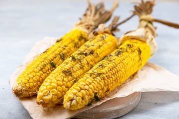 Grilled corn on cob sprinkled with parsley and grated parmesan