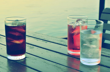Three glasses of vine and water with sparkling water on wooden table