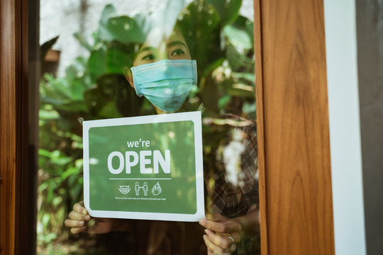 wear masks, keep your distance and wash hand sign on shop front door when new normal during coronavirus outbreak in the city open her shop for business - Powered by Adobe