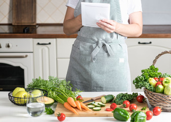 woman cooking in the kitchen. fresh healthy vegetables on a cutting board