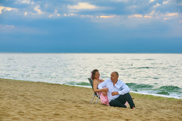 A married couple on the beach at dawn on their wedding anniversary