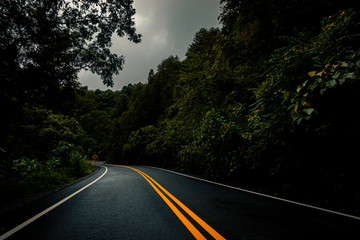Naklejka premium Logistic concept aerial view of countryside road - motorway passing through the serene lush greenery and foliage tropical rain forest mountain landscape