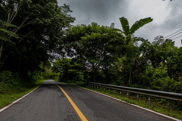 Fototapeta na wymiar Logistic concept aerial view of countryside road - motorway passing through the serene lush greenery and foliage tropical rain forest mountain landscape