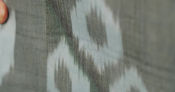 Female showing adras ikat textile closeup.. Silk road Uzbekistan Central Asia. Micro