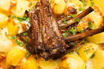 Close up on homemade marinated spicy grilled bbq ribs served on a plate with rosemary potato wedges