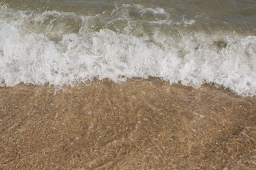 sea waves on a sandy shore in the afternoon