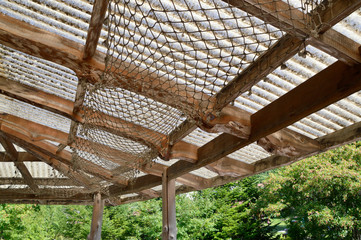 Selective focus of hanging rope mesh under roof. Creative idea for roof decoration.