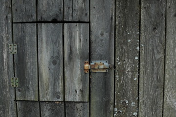 Wooden background textures. old wood texture with a cut-down window and a deadbolt. wall of an old barn.