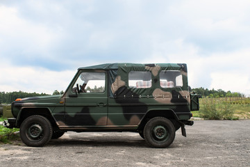 Fototapeta premium A military two-door khaki car stands in the open air
