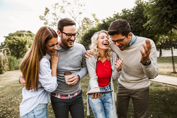 Group of friends in the park hanging out on social networks