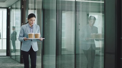 young asian trainee or secretary serving coffee to business executives in management meeting in conference room