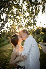 Fototapeta premium happy young couple is kissing on nature and sunset