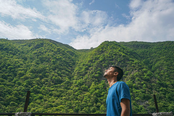 Fototapeta na wymiar Young indian boy enjoying the view of green mountains.