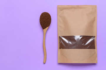 Bag and spoon with coffee powder on color background