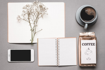 Composition with coffee, notebook and mobile phone on grey background