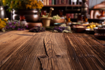 Natural medicine background. Assorted dry herbs in bowls and brass mortar on rustic wooden table.