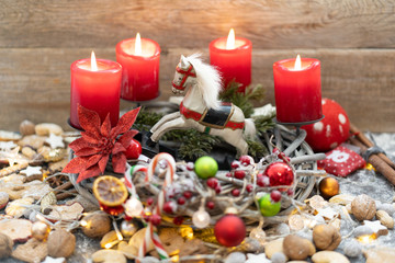 Rustikaler Adventskranz mit einem Holzschaukelpferd.