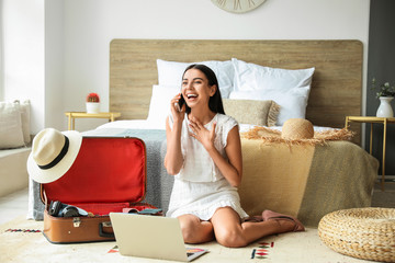 Woman with mobile phone booking tickets online at home