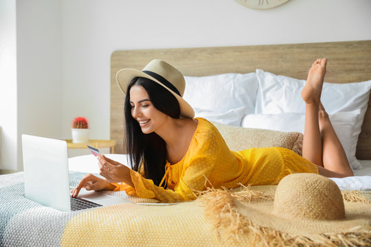 Woman with laptop booking tickets online at home