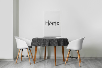 Table and chairs near light wall