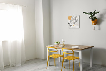 Table and chairs near light wall