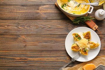 Plate with tasty conchiglioni pasta on table