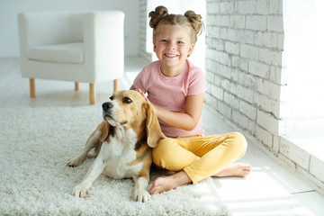 Child with a dog. Little girl plays with a dog at home. Child and animal. High quality photo.