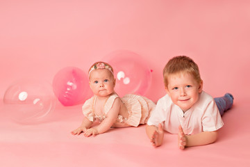 Happy child girl and boy on a pink background with balloons. Celebration. birthday