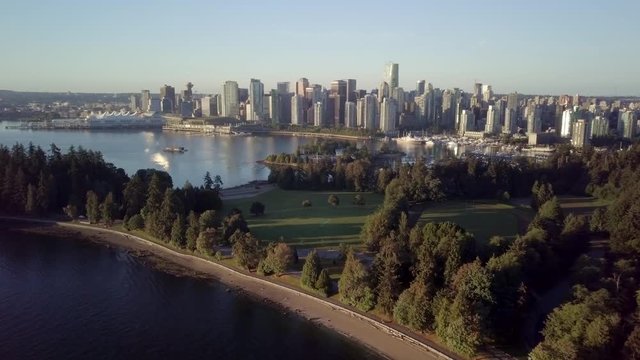 Brockton Point At Stanley Park Surrounded By The Burrard Inlet With A View Of Coal Harbour At Downtown Vancouver, Canada On A Sunrise.  - aerial drone