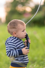 Boy talking on an old phone while standing in the middle of the street