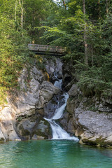 Naklejka na ściany i meble Rindbach waterfall with wooden bridge and forest. Austria alps mountain