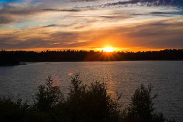 Dramatic and colorful sunset over a forest lake reflected in the water. Blakheide, Beerse, Belgium. High quality photo