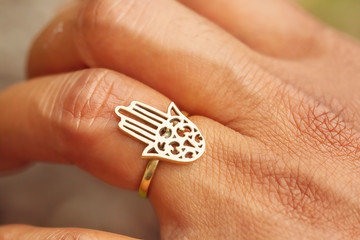 outdoor closeup of female hand with beautiful elegant hamsa fatima hand ring