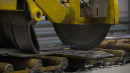 Close up of Cutting aluminium profile with robotic circular saw in manufacture. Aluminium Windows and Doors Manufacturing.