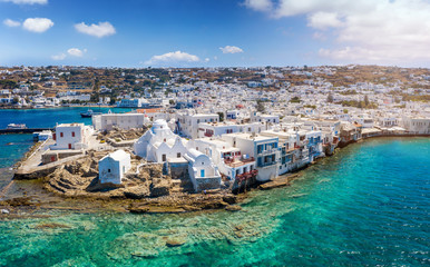 Panorama der schönen Altstadt von Mykonos mit weißen Kirchen, türkisem Meer und blauem...