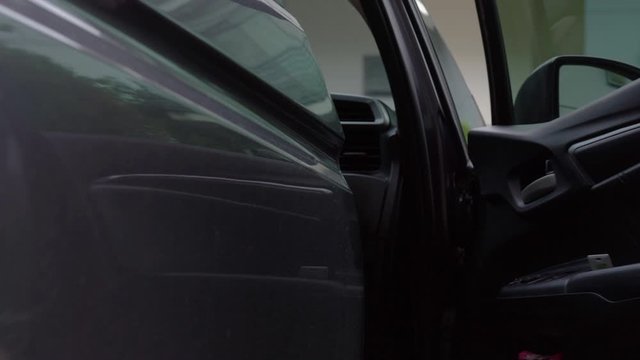 4K footage showing a cheerful woman get into the private car close up, girl opening the door and getting in the vehicle. Safe and confident driving concept.