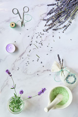 Handmade lavender sachets and aromatic herb infused bath salt. Lavender flowers, fresh and dry. Flat lay on white marble.