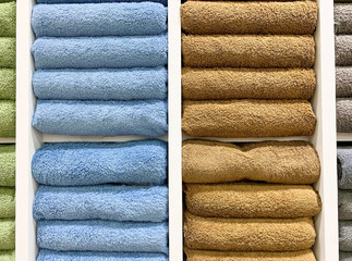 many colorful towels is folding in shelfs at store for Sales .  - 373424571